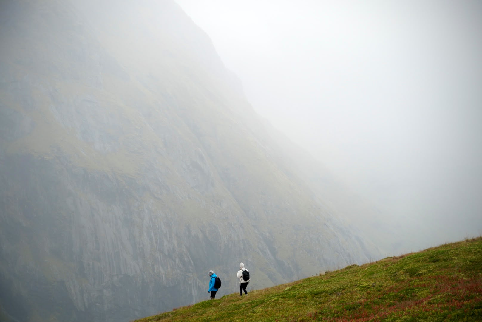 Two hikers crossing the Ryten landscape in low cloud
