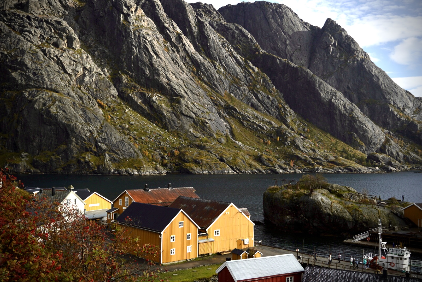 Yellow fishing cabins below steep Lofoten mountains